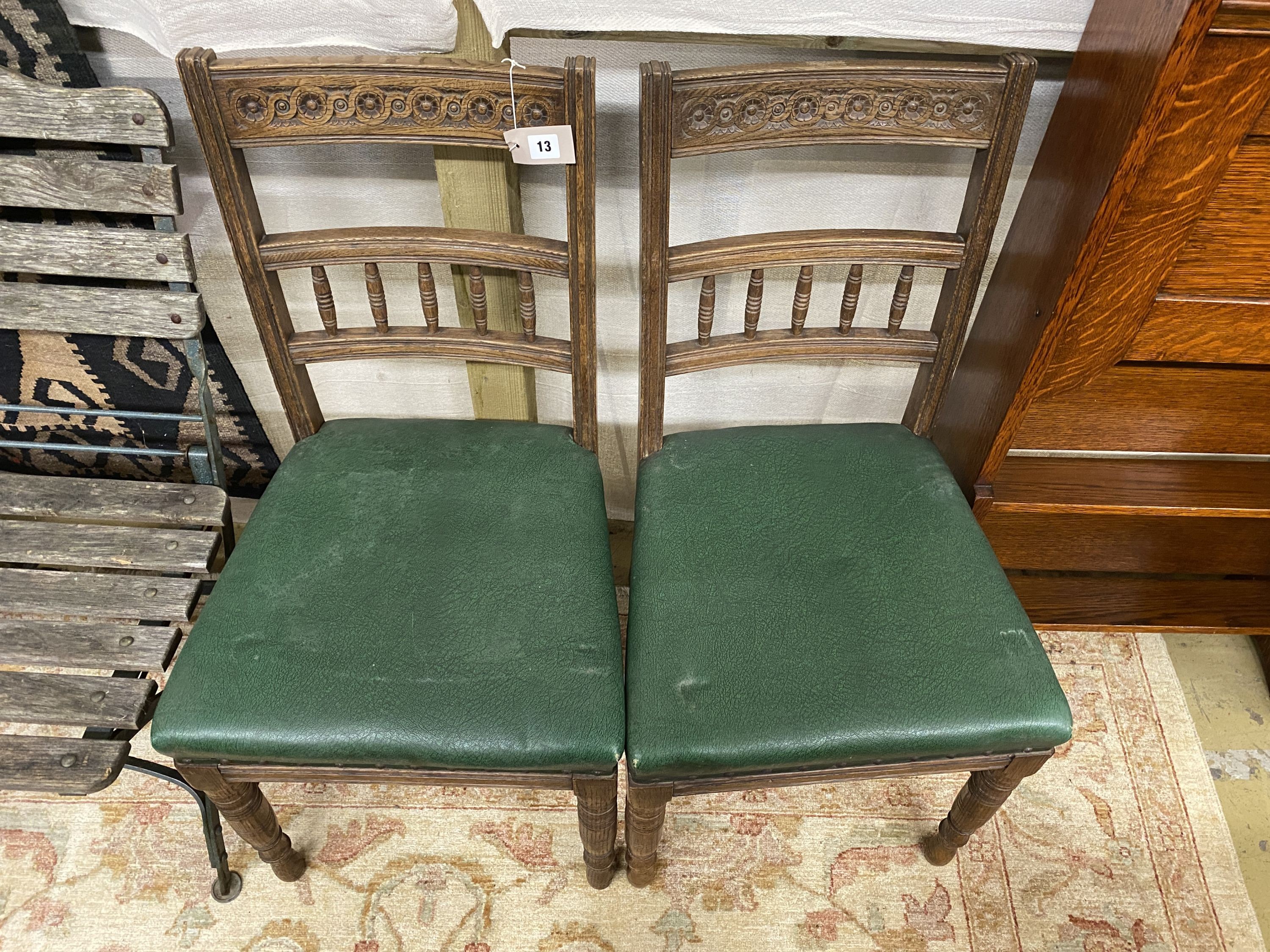 A pair of late Victorian carved oak dining chairs